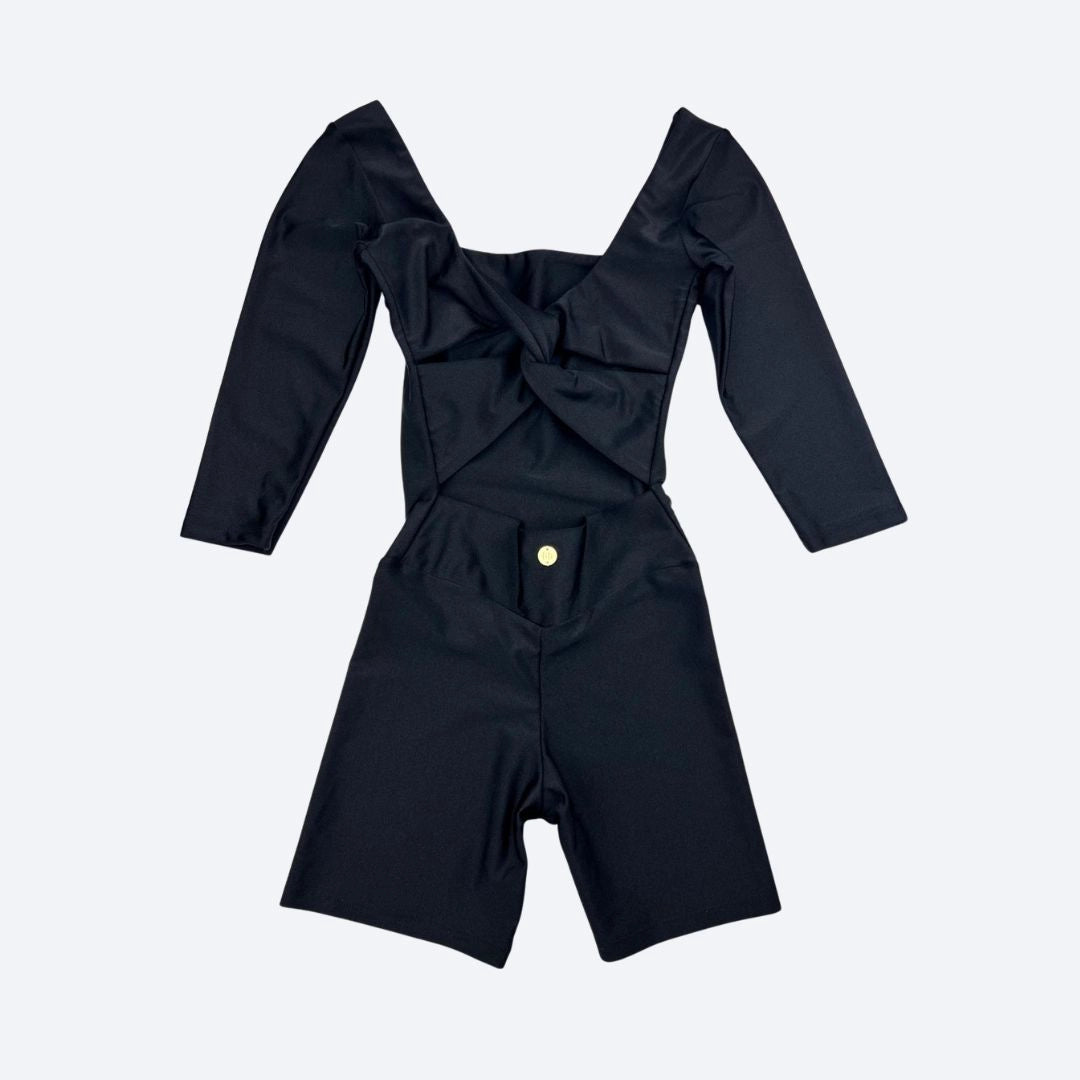 Black outfit with long sleeves and twist detail on a light gray background