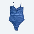 Blue women’s bodysuit with thin straps for beach or gym, displayed on a light gray background