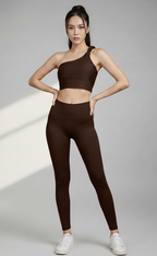 Woman wearing a elegant brown fitness crop top bra and leggings outfit on a gray background