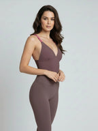Elegant woman wearing a taupe purple bodysuit on a light gray background