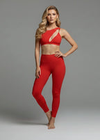 Woman wearing a red christmas stylish sports bra and red leggings on a gray background