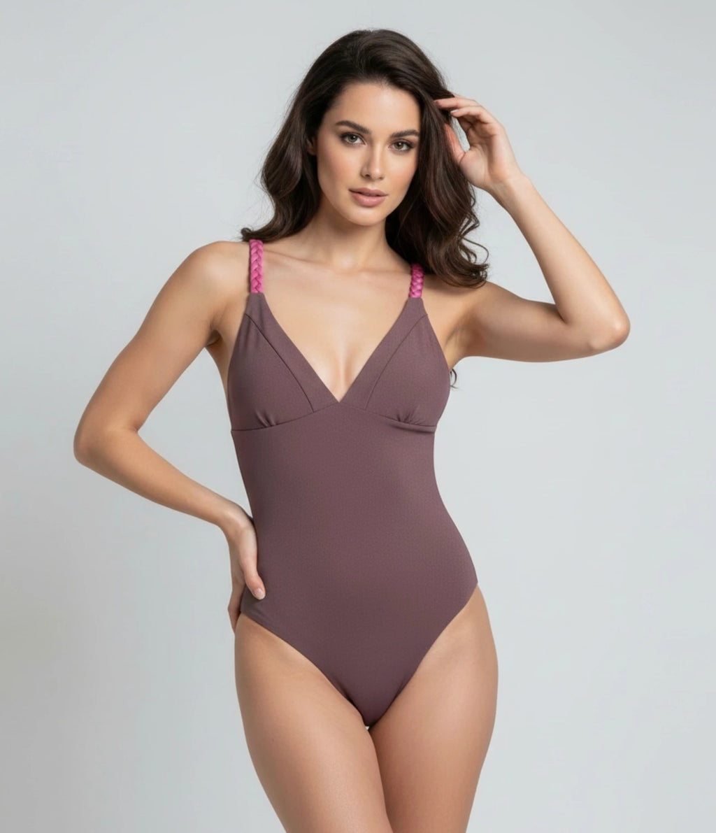 Woman wearing a taupe purple swimsuit with pink braided straps on a gray background, perfect for resort vacation, workout sessions.