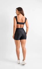 Woman wearing a black athletic outfit on a white background