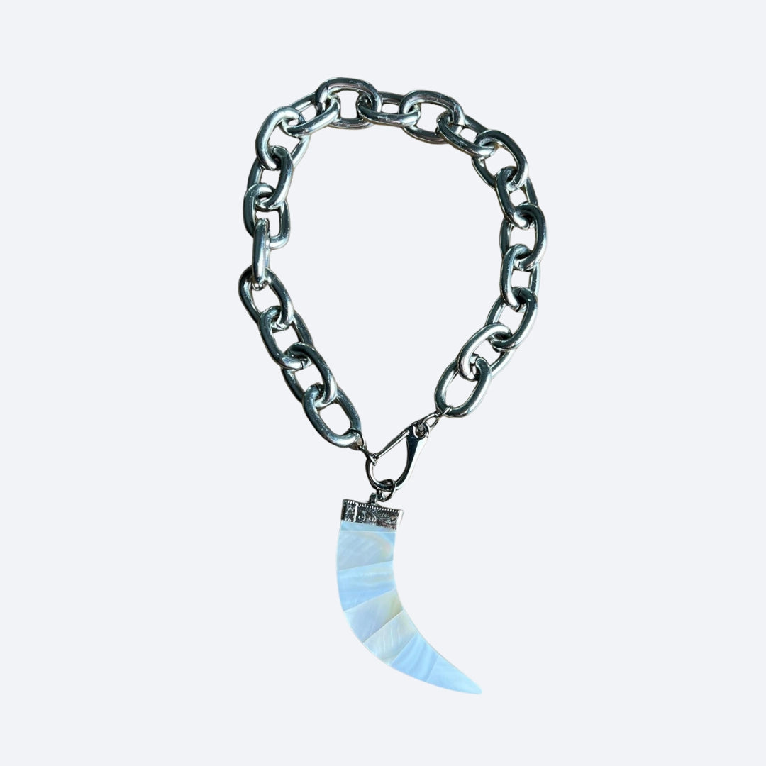 Silver chain necklace with a blue and white horn-shaped pendant on a light gray background